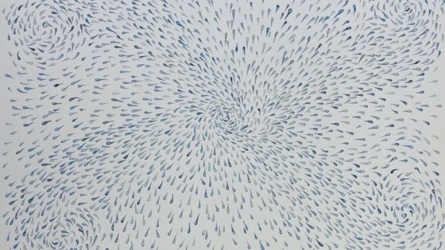 A swirling pattern of short blue strokes radiating outward from a central point, forming four spiral corners like a dotted whirlpool.